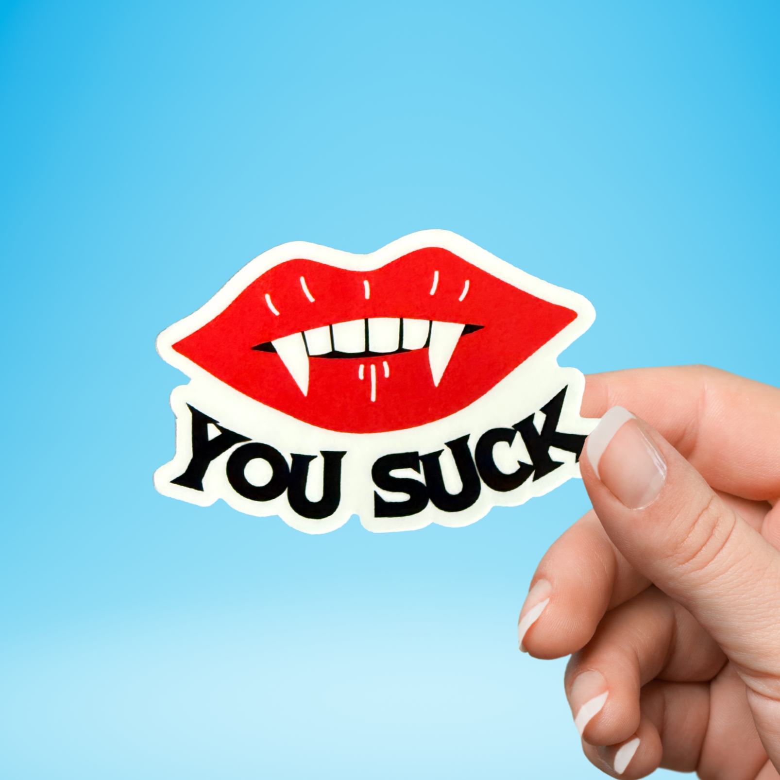 Hand holding a sticker with red lips and 'YOU SUCK' text against a blue background